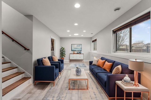 living area with recessed lighting, baseboards, stairway, and light wood-type flooring