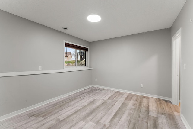 empty room with baseboards and light wood finished floors