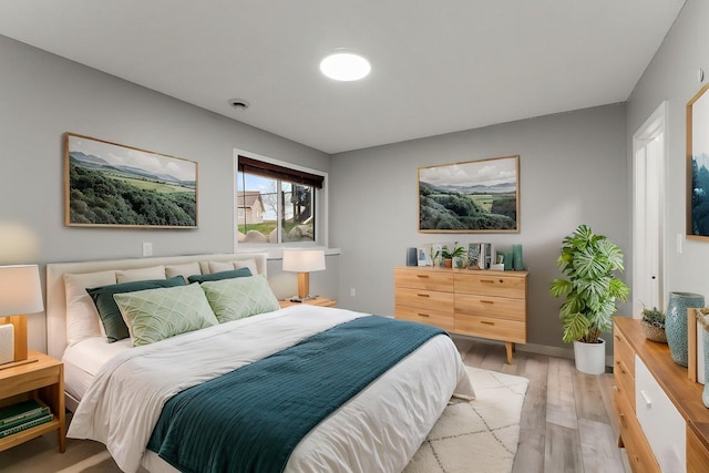 bedroom featuring baseboards and light wood finished floors