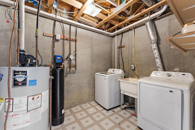laundry room with laundry area, independent washer and dryer, a sink, water heater, and light floors