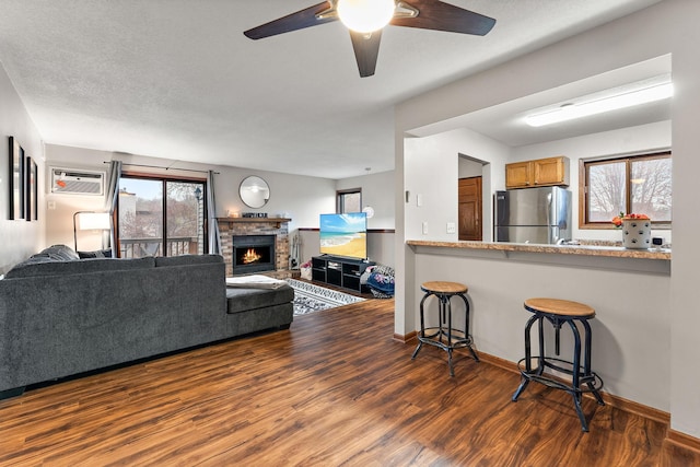 2071 Parkside Dr Unit 30, Saint Paul, MN 55119 - living area featuring wood finished floors, a ceiling fan, baseboards, a fireplace, and a wall unit AC