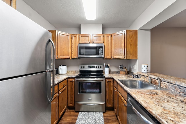 2071 Parkside Dr Unit 30, Saint Paul, MN 55119 - kitchen featuring appliances with stainless steel finishes, a sink, dark wood-style flooring, light countertops, and brown cabinets