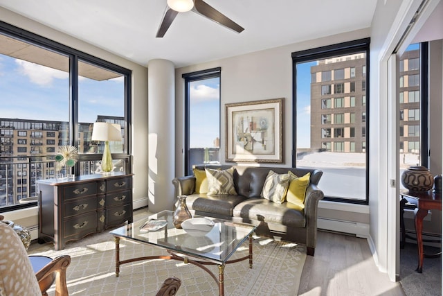 living area with baseboards, ceiling fan, a city view, and wood finished floors