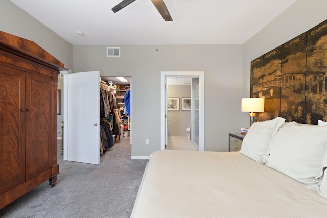 bedroom featuring visible vents, a closet, light carpet, connected bathroom, and a spacious closet