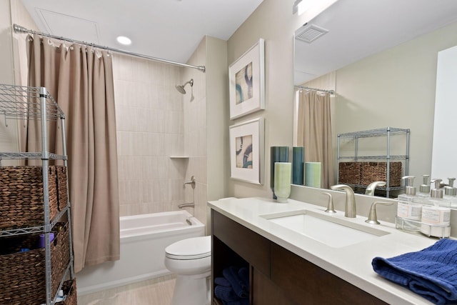 bathroom featuring vanity, shower / bath combo with shower curtain, toilet, and visible vents
