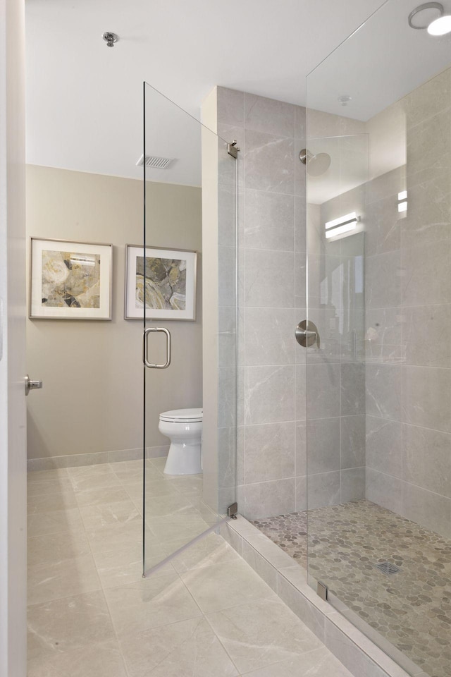 bathroom with a walk in shower, baseboards, toilet, and visible vents