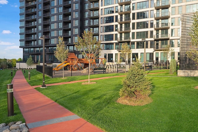 view of community with a lawn and fence