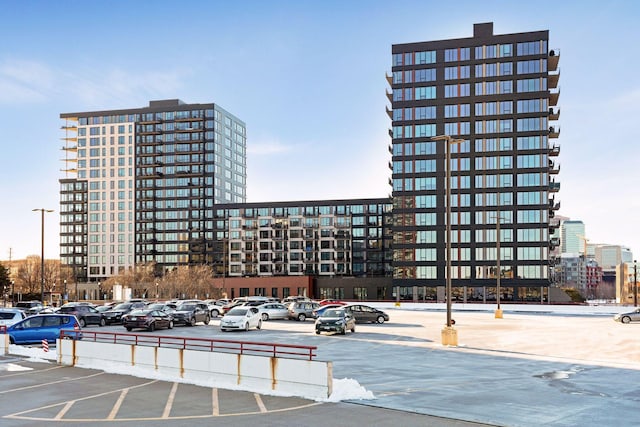 view of property with uncovered parking and a city view