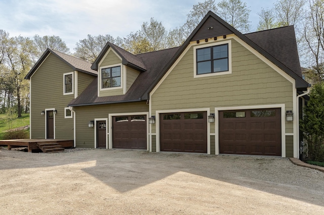 view of front facade featuring dirt driveway and a shingled roof