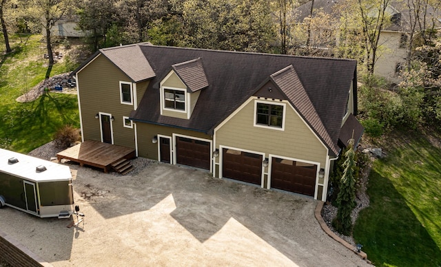 view of front of property with dirt driveway, an attached garage, and a wooden deck