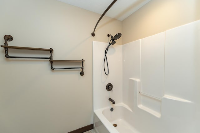 full bathroom featuring washtub / shower combination and baseboards