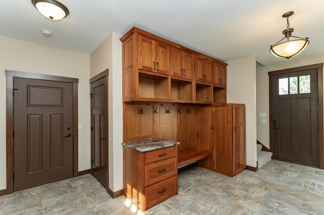 17361 Sugarloaf Pkwy, Minneola Twp, MN 55992 - mudroom featuring baseboards, built in desk, stone finish flooring, and a textured ceiling
