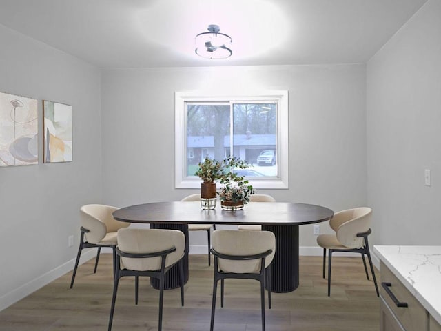 dining area featuring baseboards and light wood-style floors