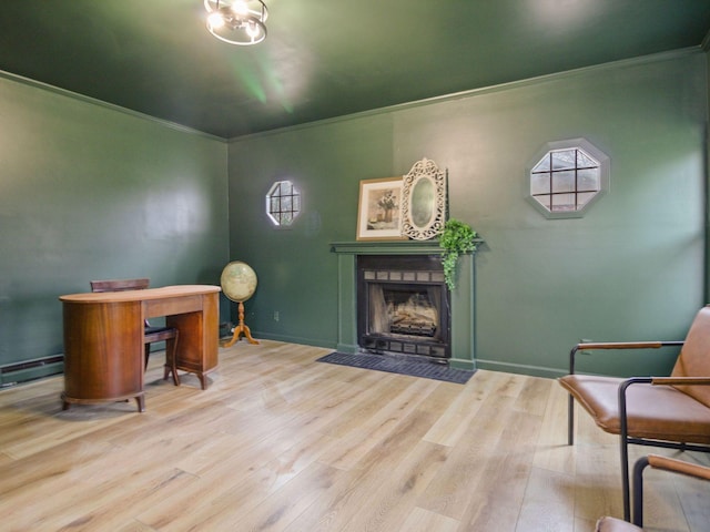 interior space featuring crown molding, a fireplace with flush hearth, and wood finished floors
