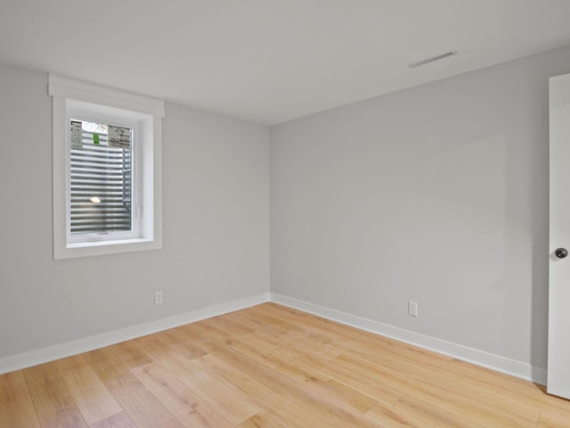 unfurnished room featuring light wood-style floors, baseboards, and visible vents