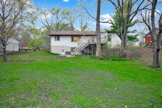 rear view of property featuring a yard, a wooden deck, stairs, and central AC unit