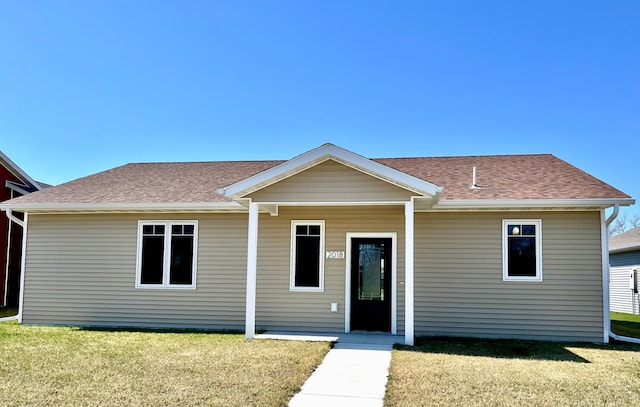 view of front facade featuring a front lawn and a shingled roof