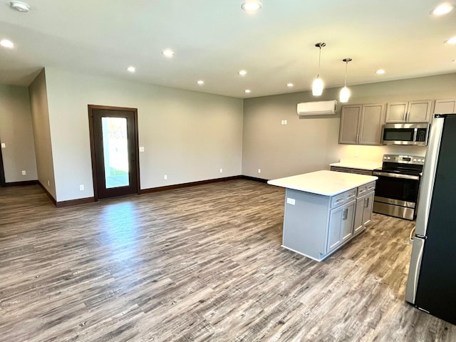 kitchen with wood finished floors, gray cabinets, baseboards, appliances with stainless steel finishes, and recessed lighting