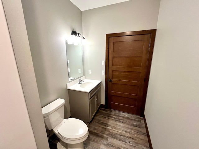 bathroom with vanity, toilet, and wood finished floors