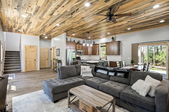 living area featuring wooden ceiling, a ceiling fan, a healthy amount of sunlight, and stairs