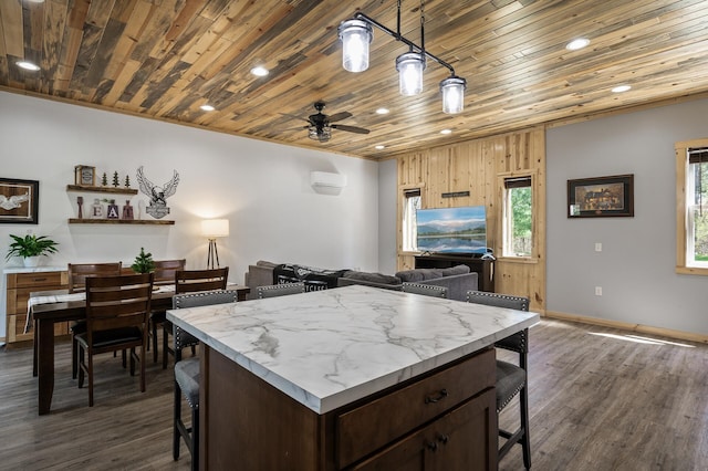 kitchen with dark wood-style flooring, a breakfast bar area, ceiling fan, and wood ceiling