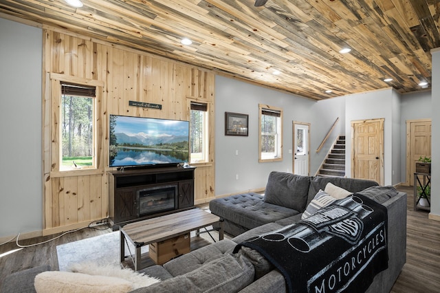 living area with stairway, wood ceiling, baseboards, and wood finished floors
