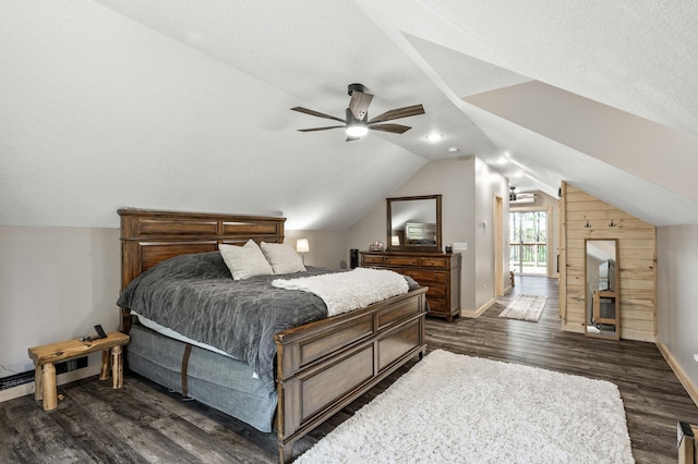 bedroom with lofted ceiling, ceiling fan, wooden walls, dark wood-style floors, and baseboards
