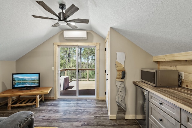 bonus room with lofted ceiling, a textured ceiling, an AC wall unit, dark wood-style floors, and a ceiling fan