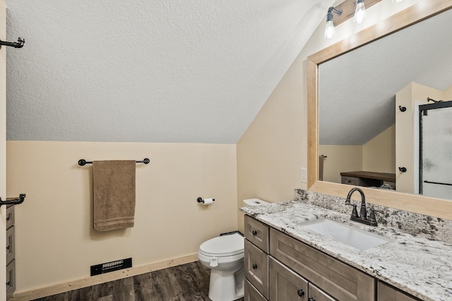 bathroom with toilet, wood finished floors, a textured ceiling, vaulted ceiling, and vanity