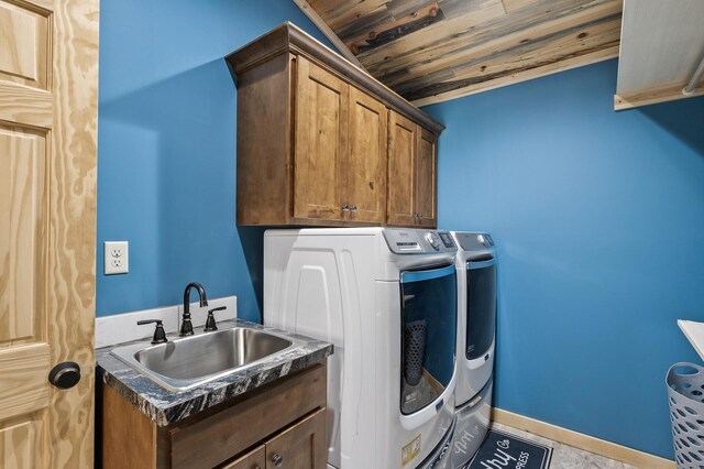 laundry area with a sink, washer and clothes dryer, cabinet space, and wooden ceiling