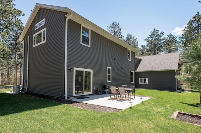 rear view of house featuring a lawn, a patio area, and central AC