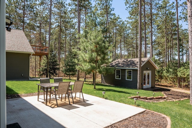 view of patio / terrace with french doors, an outbuilding, and outdoor dining area