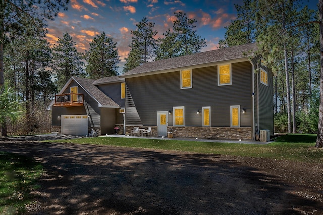 6070 Aspen Rd, Princeton, MN 55371 - view of front of home featuring central air condition unit, stone siding, a front lawn, and driveway