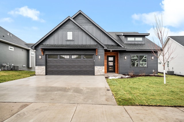 view of front of home with an attached garage, concrete driveway, a front lawn, and cooling unit