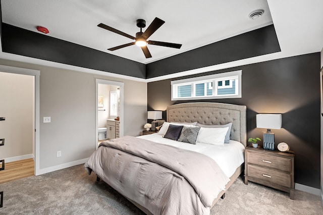 bedroom featuring visible vents, carpet floors, baseboards, ceiling fan, and connected bathroom