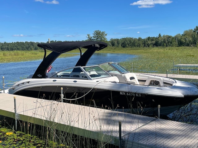 dock area featuring a water view and a wooded view