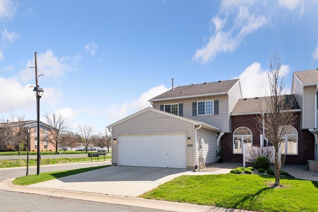 traditional-style house with a garage, a front yard, and concrete driveway