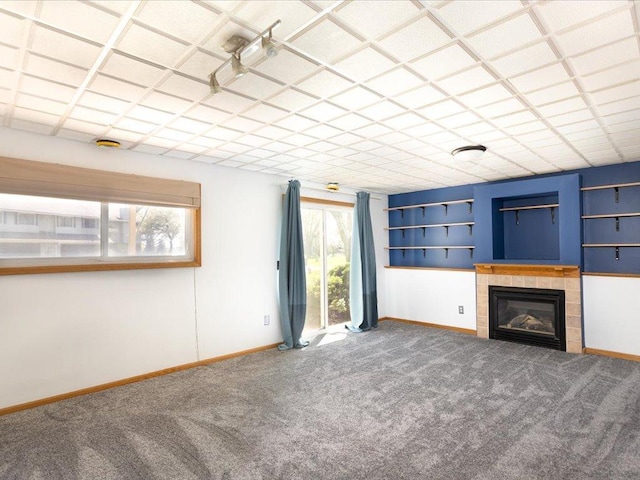 1042 Aston Cir, Burnsville, MN 55337 - unfurnished living room with carpet floors, baseboards, a tiled fireplace, and built in shelves