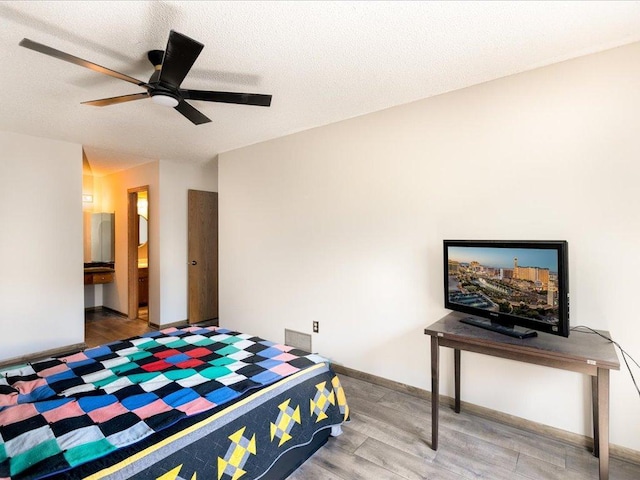 1042 Aston Cir, Burnsville, MN 55337 - bedroom with wood finished floors, baseboards, ceiling fan, a textured ceiling, and ensuite bath