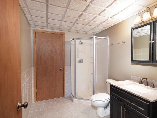1042 Aston Cir, Burnsville, MN 55337 - full bathroom with a stall shower, toilet, vanity, tile walls, and tile patterned floors