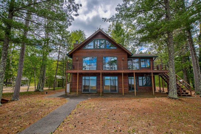 10121 Comstock Rd, Hayward, WI 54843 - back of property featuring stairs, a chimney, and a deck