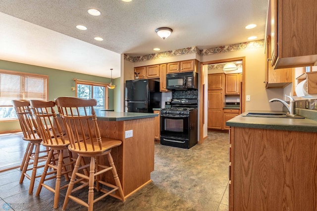 23898 324th Ave, Sverdrup Twp, MN 56586 - kitchen with a sink, a breakfast bar, black appliances, recessed lighting, and dark countertops