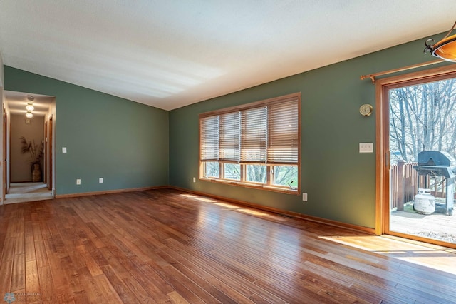 23898 324th Ave, Sverdrup Twp, MN 56586 - unfurnished room with plenty of natural light, vaulted ceiling, baseboards, and hardwood / wood-style flooring