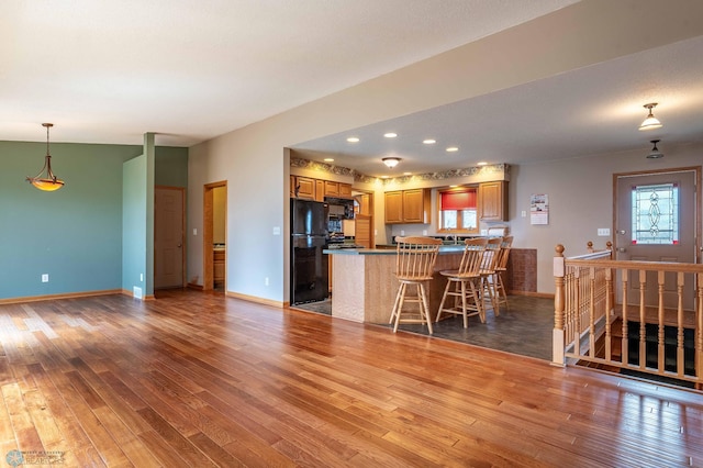 23898 324th Ave, Sverdrup Twp, MN 56586 - kitchen featuring light wood finished floors, a peninsula, brown cabinets, and black appliances