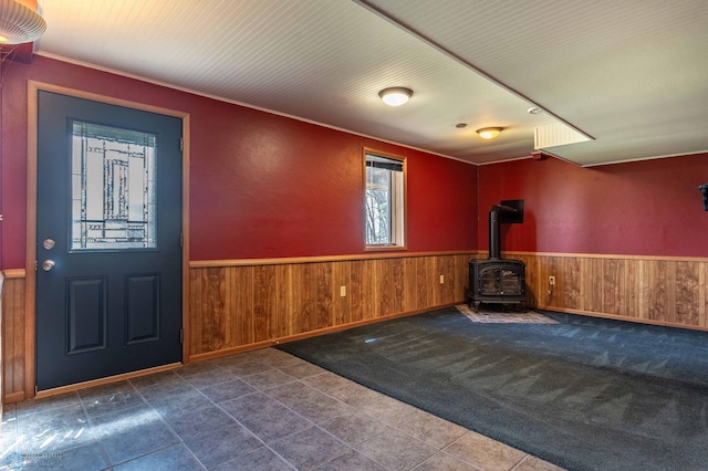 23898 324th Ave, Sverdrup Twp, MN 56586 - entrance foyer with wainscoting, a wood stove, wooden walls, and tile patterned floors