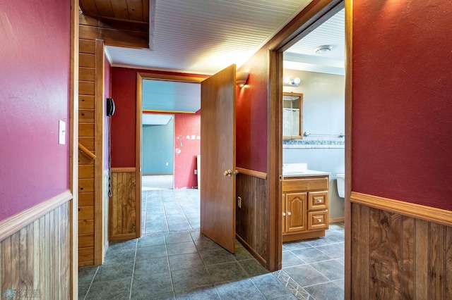 23898 324th Ave, Sverdrup Twp, MN 56586 - corridor with wood walls, dark tile patterned flooring, and a wainscoted wall