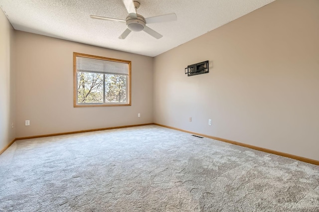 unfurnished room with carpet, baseboards, a textured ceiling, and a ceiling fan
