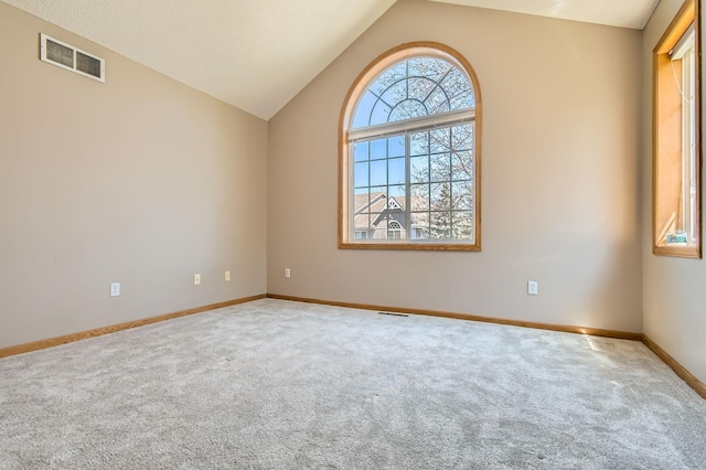 spare room with carpet, lofted ceiling, and baseboards