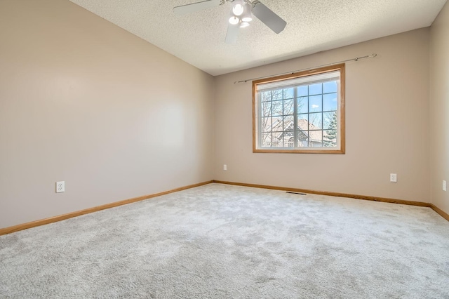 spare room featuring carpet floors, a textured ceiling, baseboards, and a ceiling fan