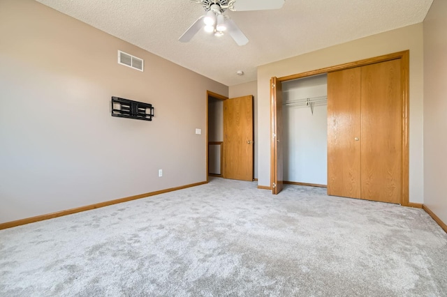 unfurnished bedroom featuring carpet floors, baseboards, a closet, a ceiling fan, and a textured ceiling